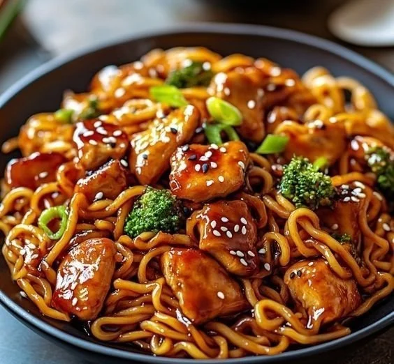 Plate of Chicken Teriyaki Noodles garnished with sesame seeds and green onions