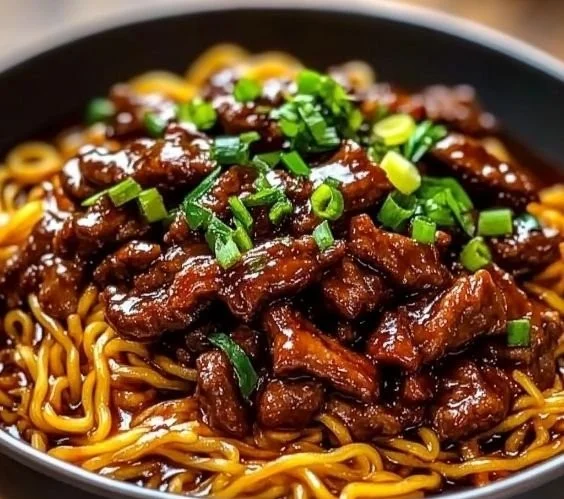 Sticky Beef Noodles 2 Delicious sticky beef noodles served in a bowl with fresh herbs and spices