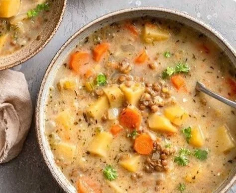 Vegetarian Lentil Soup 2 Bowls of delicious vegetarian lentil soup garnished with herbs.