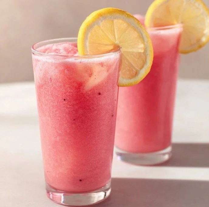 Refreshing Frozen Hibiscus Lemonade with vibrant color and garnishes.