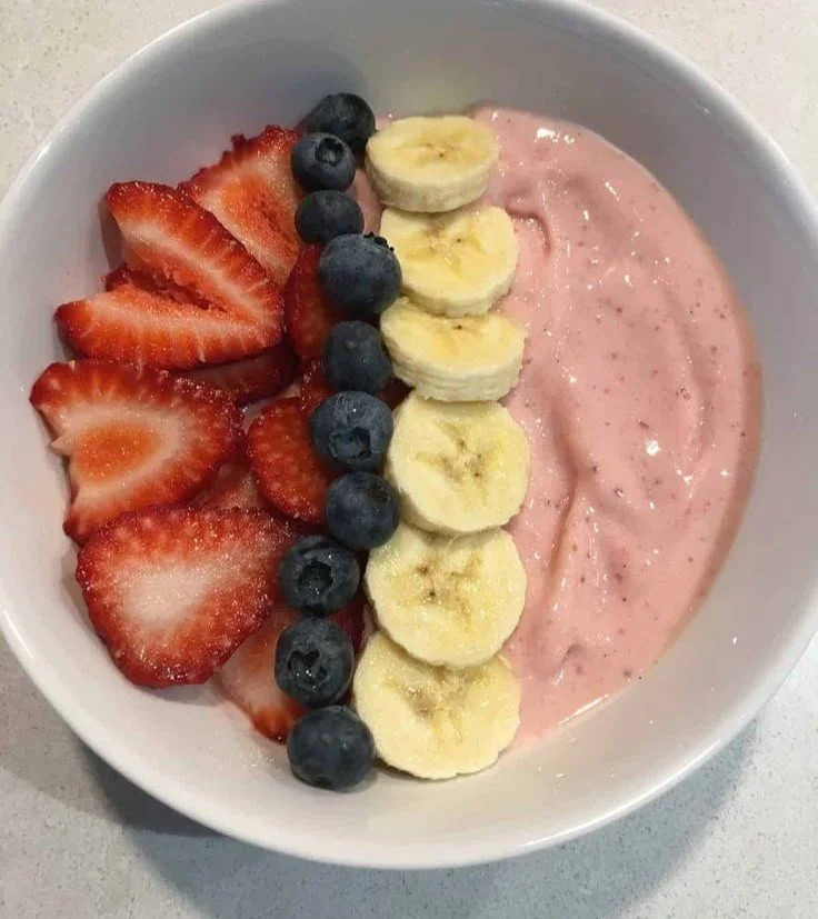 Delicious strawberry banana smoothie bowl topped with fresh fruits and nuts