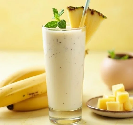 Delicious Banana Pineapple Smoothie in a glass with tropical fruits