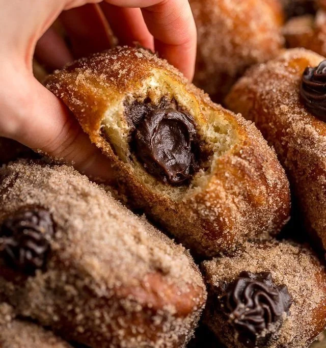Chocolate hazelnut cream doughnuts topped with chocolate glaze and nuts