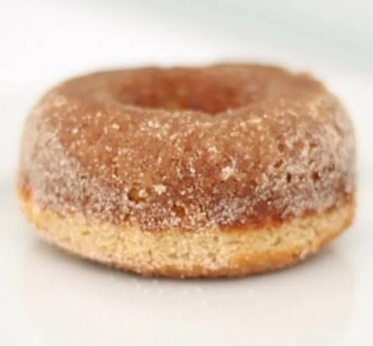 Freshly baked cinnamon doughnuts with a golden coating and spiced flavor