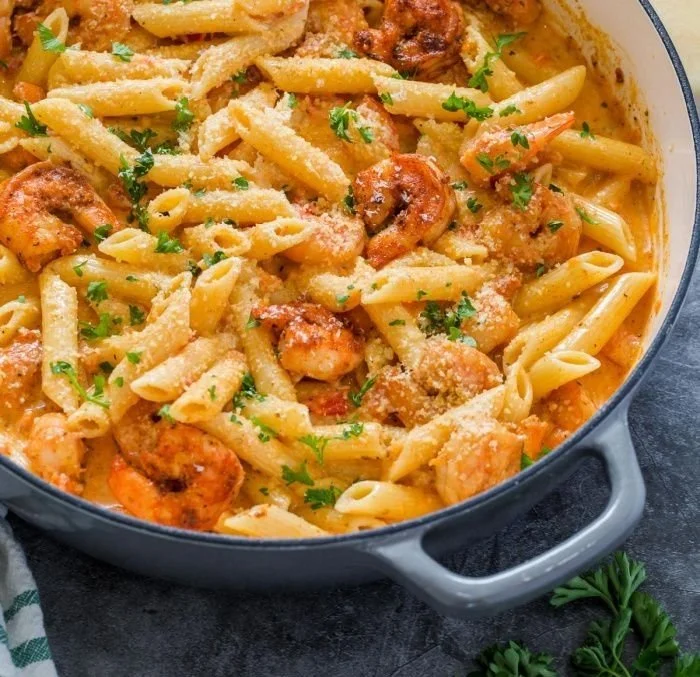 Creamy Cajun shrimp pasta with spices and sauces, served in a bowl.