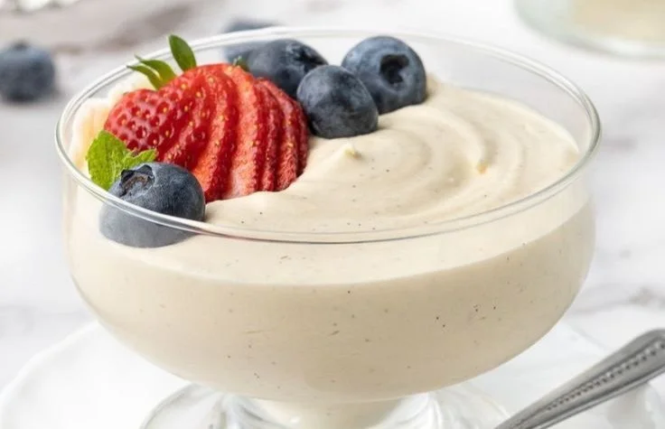A delicious bowl of creamy vanilla mousse topped with fresh berries.