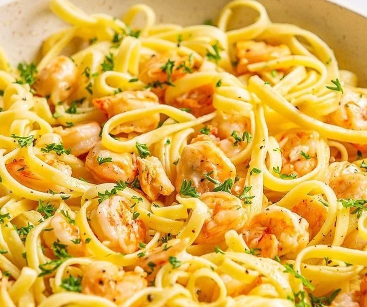 Delicious garlic butter shrimp pasta garnished with parsley on a plate