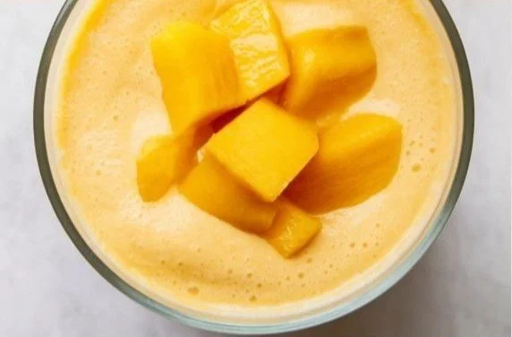 High-Protein Mango Smoothie 4 High-protein mango smoothie in a glass with fruit and protein powder