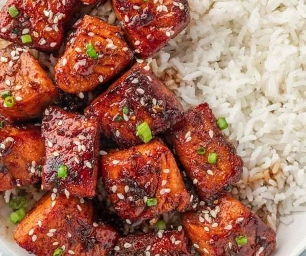Plate of delicious honey glazed salmon bites garnished with herbs