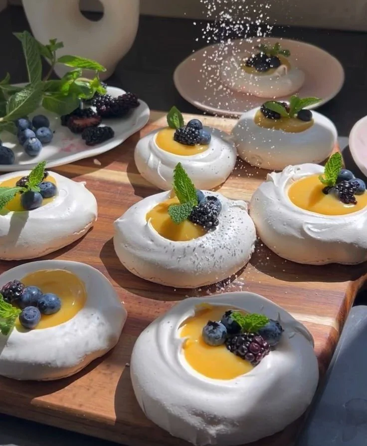 Plate of mini meringues topped with vibrant citrus curd.