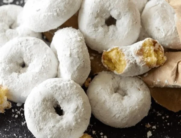 Mini powdered sugar doughnuts freshly baked and dusted with sugar