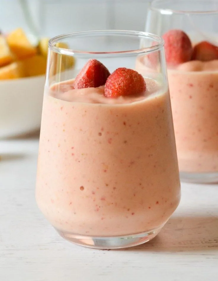 Strawberry Mango Banana Smoothie in a glass with fresh fruits