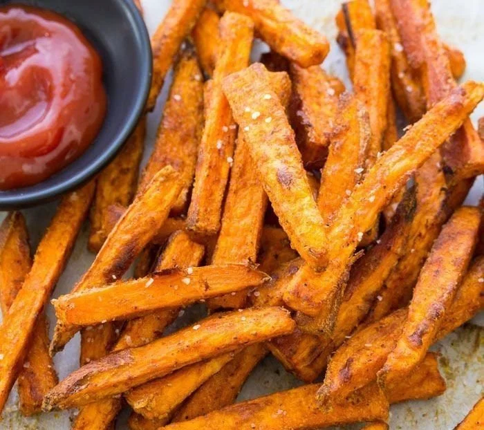 Crispy baked sweet potato fries served on a plate with dipping sauce
