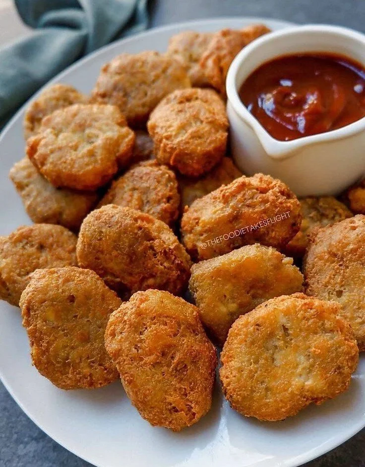 Crispy Tofu McNuggets served with dipping sauce on a plate.