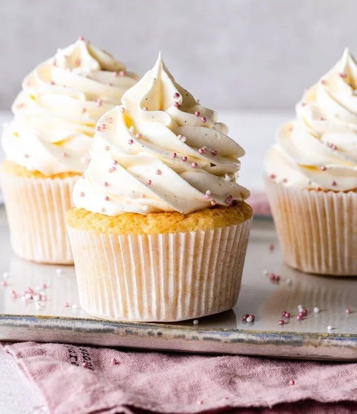 Delicious vanilla cupcakes with creamy frosting on a decorative plate
