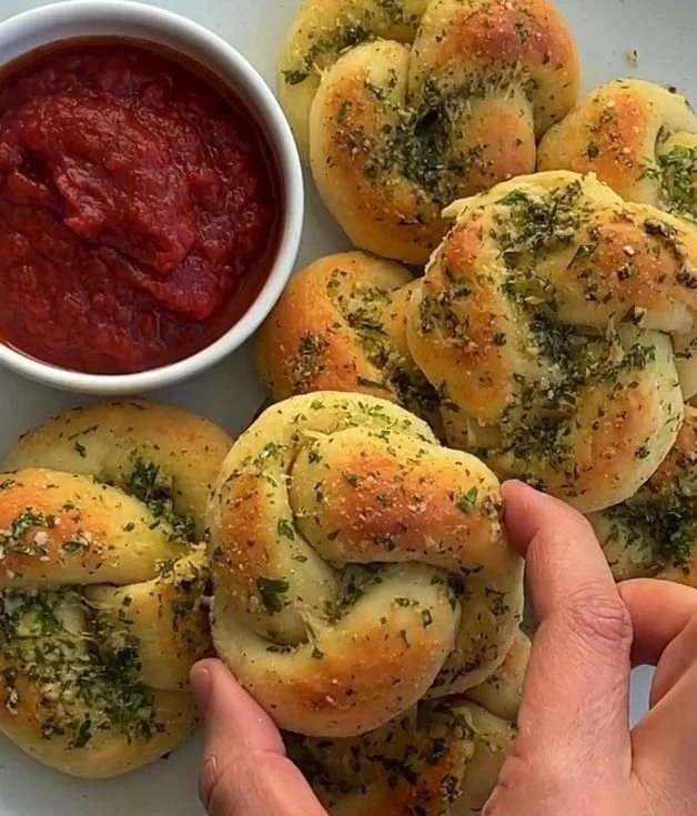 Freshly baked garlic knots with buttery garlic glaze and herbs