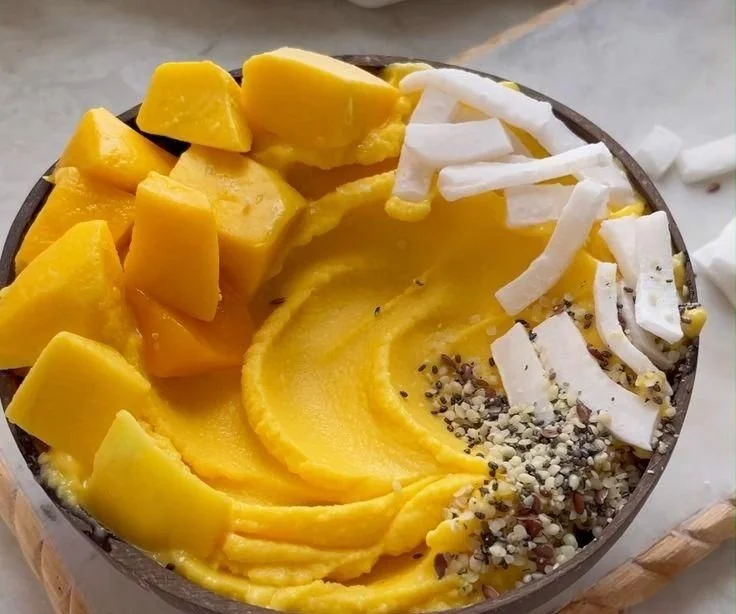 Thick Mango Smoothie Bowl 4 Thick mango smoothie bowl topped with fruits and seeds